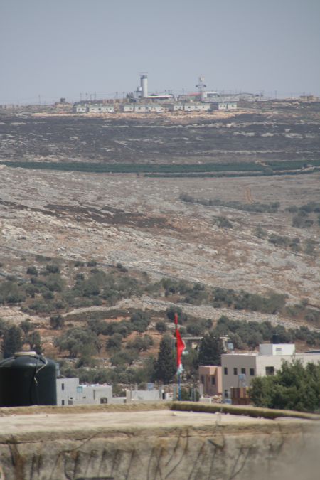 A tattered flag flies below the Bracha settlement in Nablus, Palestine