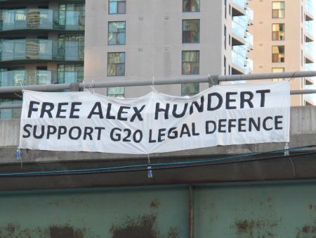 Environmental Justice Toronto activists drop banner off Gardiner Expressway  demanding freedom for G20 arrestee Alex Hundert