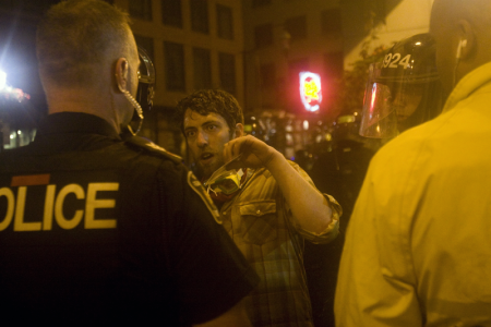 Rosenfeld shows his media credentials to police right before he is arrested and beaten. Photo: Activestills