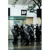 Police guard corporate storefronts going on 24 hours of sweeping mass arrests and street clashes