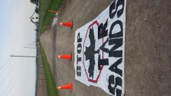 Stop the Tar Sands banner is laid out at the entrance to the site
