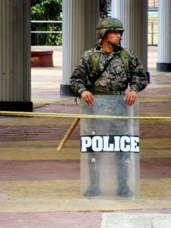 Nov. 27, 2009 - A few feet away, a military officer holds a riot shield that answers the question.