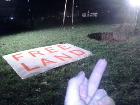 "Free land' in Simcoe Park. Basically digging a hole in a highly landscaped plot with no real dirt and giving out the soil. Fellow Nuit Blanche traveller. They called it "liberated soil". Liberated soil with a permit? But it turns out there might be more to this piece than I thought...