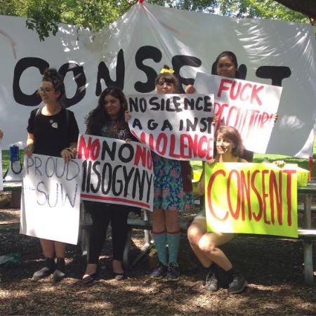 Organizers stand in front of the large "CONSENT" banner. [Credit: Nyssa Komorowski]