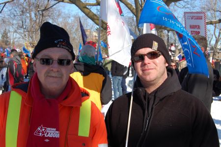John Whitty (left) worked at the Electro-Motive Diesel (EMD) plant for 33 years. His son Chris (right) is now a maintenance electrician at EMD who has been locked out for over three weeks when workers rejected a proposed 50% wage cut. The Ontario Federation of Labour held a rally in Victoria Park in London, Ont. on Jan. 21  Photo: Mick Sweetman